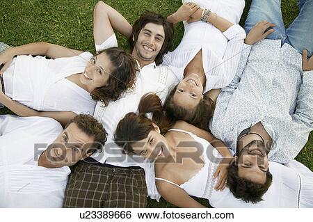 Six young people lying on grass (portrait, directly above) View Large Photo Image Stock Photograph - Six young people lying on grass (portrait, directly above). Fotosearch