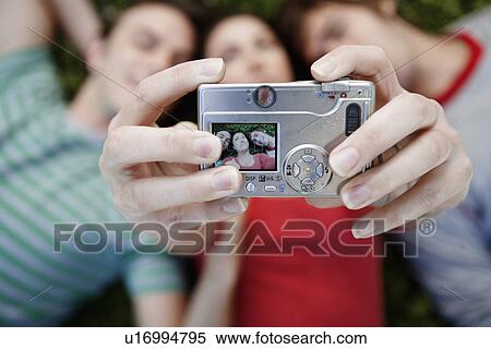 Stock Photography - Three friends photographing themselves (directly above). Fotosearch