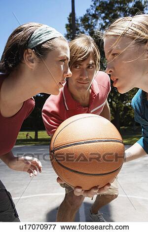Three people playing basketball View Large Photo Image Stock Photo - Three people playing basketball. Fotosearch
