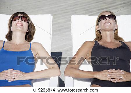 Picture - Two women sunbathing (high angle view). Fotosearch