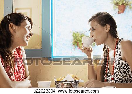 Two women talking at dining table View Large Photo Image Picture - Two women talking at dining table. Fotosearch
