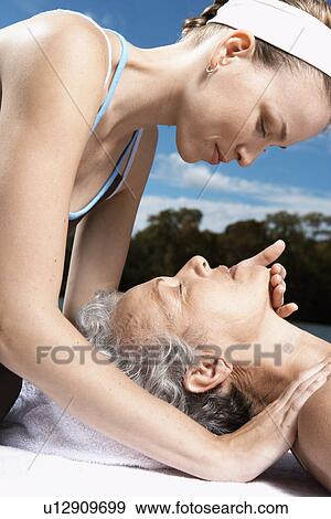 Young woman touching her mother's face View Large Photo Image Stock Photo - Young woman touching her mother's face. Fotosearch