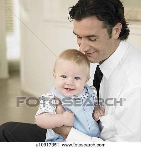 Stock Image - Mid adult man with son (1-2). Fotosearch
