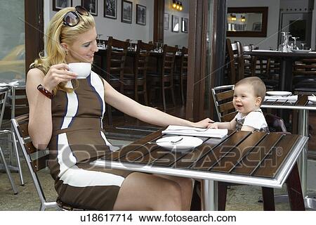 Mid adult mother with baby girl in café View Large Photo Image Picture - Mid adult mother with baby girl in café. Fotosearch