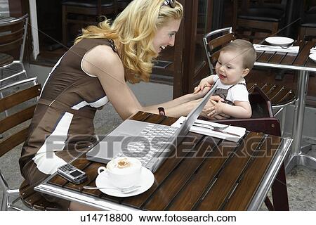 Mid adult woman with laptop talking to her baby daughter View Large Photo Image Stock Image - Mid adult woman with laptop talking to her baby daughter. Fotosearch