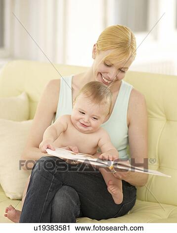 Stock Image - Mother and Baby Boy Looking at Picture Book. Fotosearch