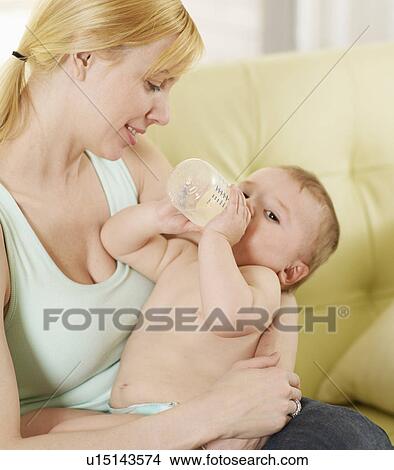 Picture - Mother Holding Baby Boy with Milk Bottle. Fotosearch