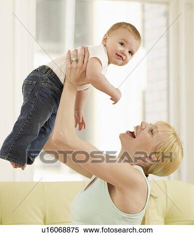 Stock Photography - Mother Lifting Baby Boy. Fotosearch