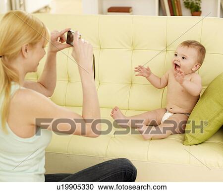 Stock Image - Mother Photographing Baby Boy. Fotosearch