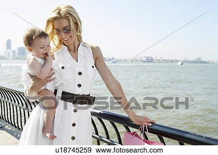 Stock Photo - Mother with baby girl at waterfront, New York City, New York, USA. Fotosearch