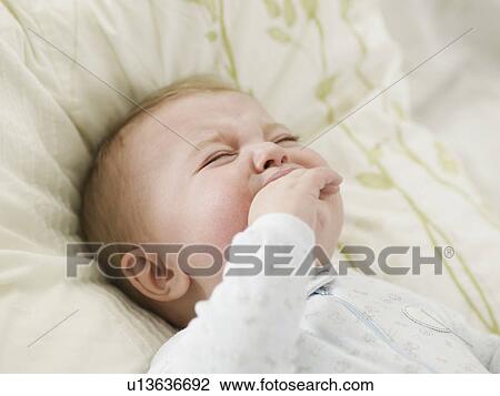 Stock Image - Unhappy Baby Boy Sucking Hand. Fotosearch