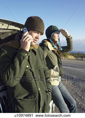 Couple with broken car, man on the phone View Large Photo Image Stock Image - Couple with broken car, man on the phone. Fotosearch