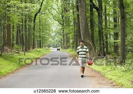 Man carrying gas canister, car out of gas in background View Large Photo Image Stock Photo - Man carrying gas canister, car out of gas in background. Fotosearch