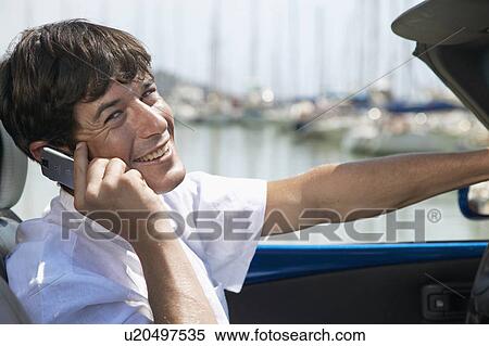 Mid-Adult Man Driving Car and Talking on Phone View Large Photo Image Stock Photography - Mid-Adult Man Driving Car and Talking on Phone. Fotosearch