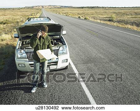 Mid adult man with road map talking on cell phone by broken car, high angle view View Large Photo Image Stock Image - Mid adult man with road map talking on cell phone by broken car, high angle view. Fotosearch