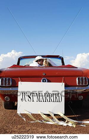 Newlyweds kissing in convertible View Large Photo Image Stock Photo - Newlyweds kissing in convertible. Fotosearch