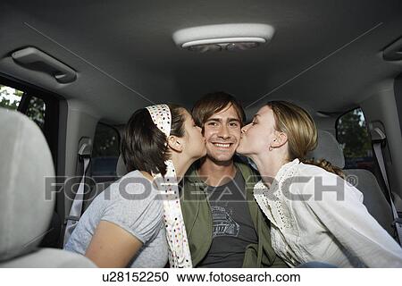 Two women kissing young man on back seat (portrait) View Large Photo Image Stock Image - Two women kissing young man on back seat (portrait). Fotosearch
