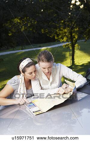 Two women reading road map on car View Large Photo Image Stock Image - Two women reading road map on car. Fotosearch