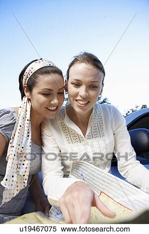 Two women reading road map View Large Photo Image Stock Photography - Two women reading road map. Fotosearch