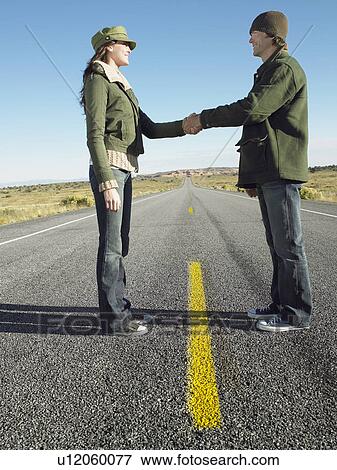 Woman and man shaking hands on highway, low angle view View Large Photo Image Stock Photo - Woman and man shaking hands on highway, low angle view. Fotosearch