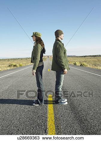 Woman and man standing back to back on highway View Large Photo Image Stock Image - Woman and man standing back to back on highway. Fotosearch