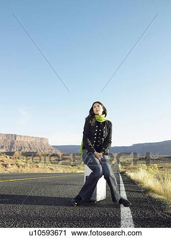 Woman hitchhiking on rural road View Large Photo Image Stock Image - Woman hitchhiking on rural road. Fotosearch