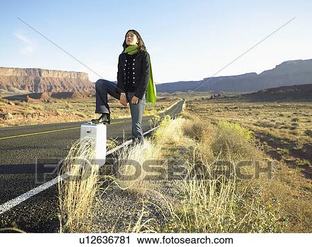 Woman hitchhiking on rural road View Large Photo Image Stock Image - Woman hitchhiking on rural road. Fotosearch