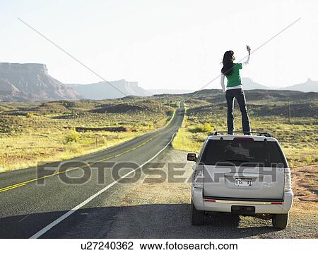 Woman using cell phone on roof of car, rear view, Moab, Utah, USA View Large Photo Image Stock Image - Woman using cell phone on roof of car, rear view, Moab, Utah, USA. Fotosearch