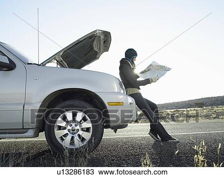 Woman with broken car looking at road map View Large Photo Image Stock Image - Woman with broken car looking at road map. Fotosearch