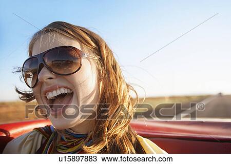 Young woman shouting in convertible View Large Photo Image Stock Image - Young woman shouting in convertible. Fotosearch