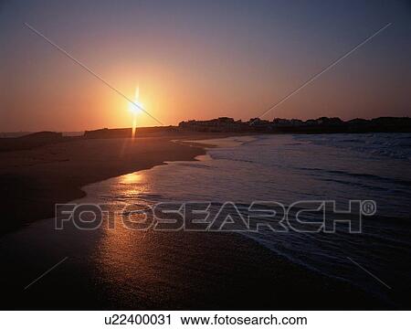 Stock Image - Sun Setting Over Beach. Fotosearch