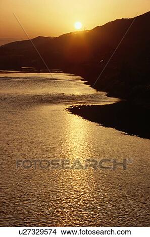 Picture - Sun Setting Over Coastline. Fotosearch