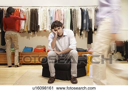 Bored young man in women's clothing store View Large Photo Image Stock Image - Bored young man in women's clothing store. Fotosearch