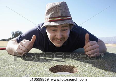 Man holding thumbs up by golf hole View Large Photo Image Stock Photo - Man holding thumbs up by golf hole. Fotosearch