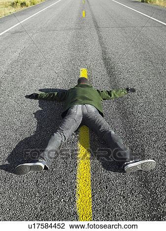 Man lying on centerline View Large Photo Image Stock Image - Man lying on centerline. Fotosearch