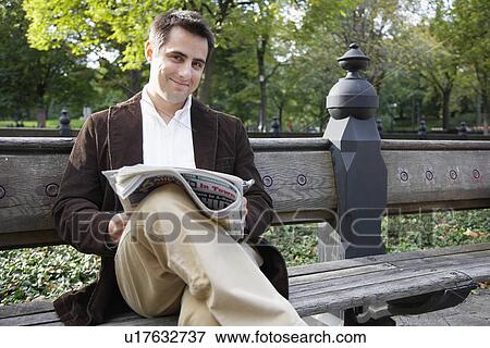 Man reading newspaper on bench (portrait) View Large Photo Image Stock Photo - Man reading newspaper on bench (portrait). Fotosearch