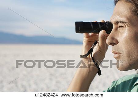 Man using monocular in desert View Large Photo Image Picture - Man using monocular in desert. Fotosearch