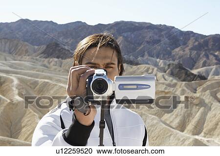 Man using video camera in desert, Death Valley, California, USA View Large Photo Image Stock Image - Man using video camera in desert, Death Valley, California, USA. Fotosearch