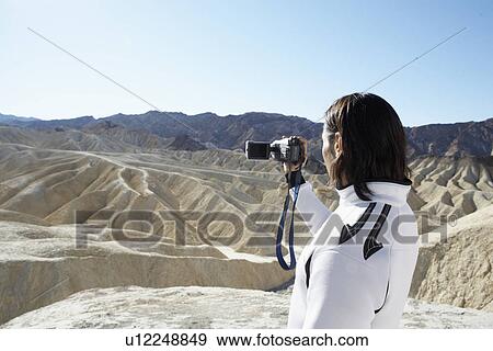 Man using video camera in desert, Death Valley, California, USA View Large Photo Image Stock Photo - Man using video camera in desert, Death Valley, California, USA. Fotosearch