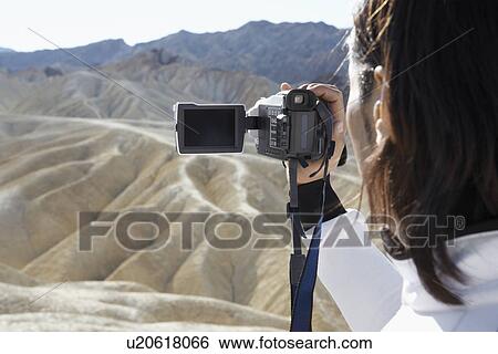 Man using video camera in desert View Large Photo Image Stock Photograph - Man using video camera in desert. Fotosearch