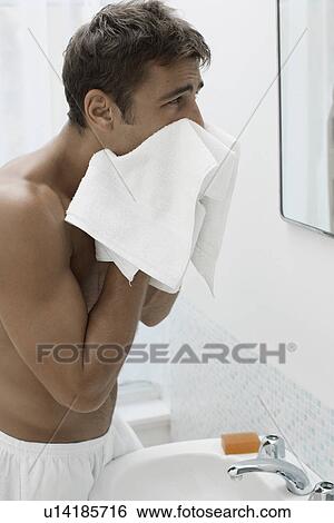 Mid adult man drying face with towel View Large Photo Image Stock Photograph - Mid adult man drying face with towel. Fotosearch