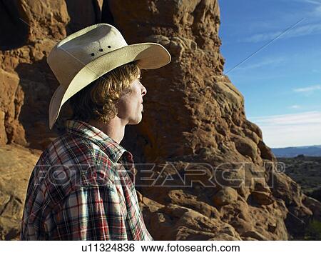 Stock Photograph - Mid Adult Man in Cowboy Hat Looking View. Fotosearch
