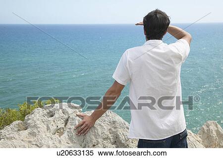 Stock Photography - Mid-Adult Man Looking at Sea. Fotosearch