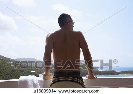 Mid adult man looking at view from balcony, St. John, US Virgin Islands, USA View Large Photo Image Picture - Mid adult man looking at view from balcony, St. John, US Virgin Islands, USA. Fotosearch