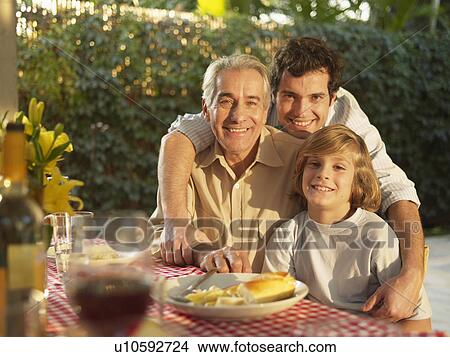 Three generation family of men by dining table (portrait) View Large Photo Image Picture - Three generation family of men by dining table (portrait). Fotosearch
