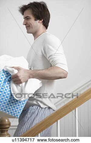 Young man carrying laundry basket View Large Photo Image Stock Photo - Young man carrying laundry basket. Fotosearch