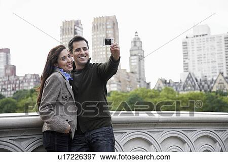 Couple photographing themselves View Large Photo Image Stock Photo - Couple photographing themselves. Fotosearch