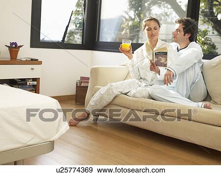 Couple sitting on sofa in morning View Large Photo Image Stock Photo - Couple sitting on sofa in morning. Fotosearch