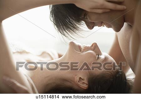 Picture - Young couple embracing on bed. Fotosearch