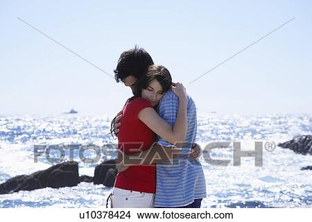 Young couple hugging by sea View Large Photo Image Picture - Young couple hugging by sea. Fotosearch